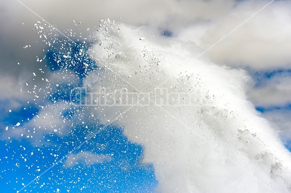 Photo of snow from snowblower against blue sky