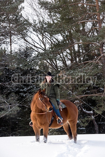 Portrait of a woman horseback riding in the snow