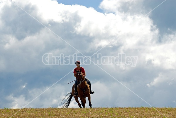 Woman horseback riding against big sky background