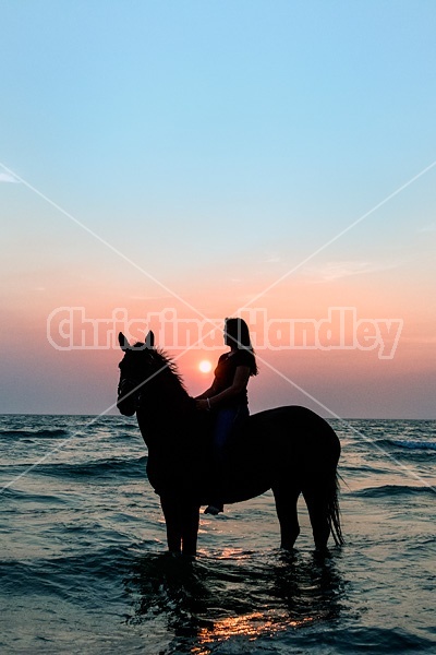 Silhouette photo of woman riding a horse bareback.