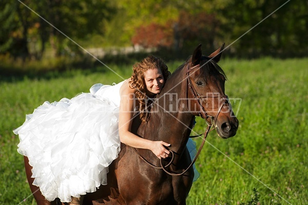 Woman riding horse wearing a wedding dress Handley Stock Photos