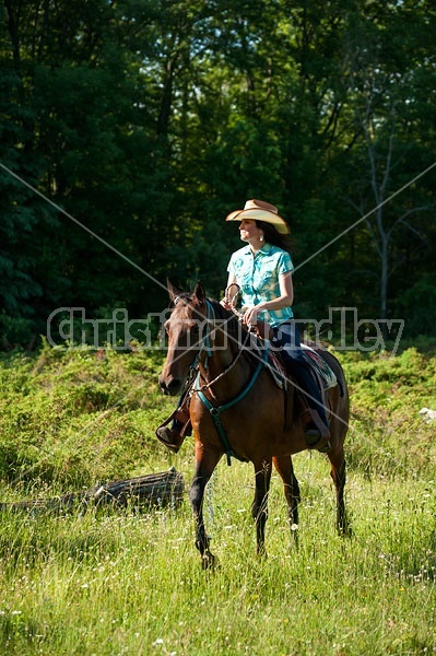 Woman trail riding on Standardbred mare