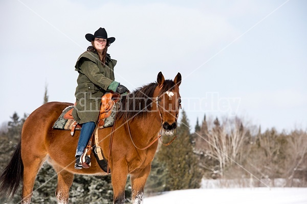 Portrait of a woman horseback riding in the snow