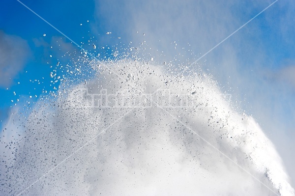 Photo of snow from snowblower against blue sky