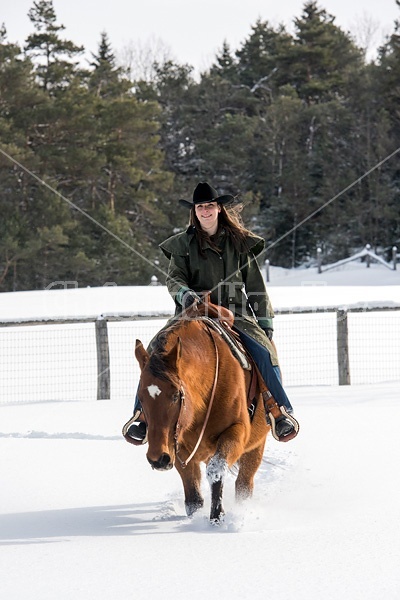 Portrait of a woman horseback riding in the snow