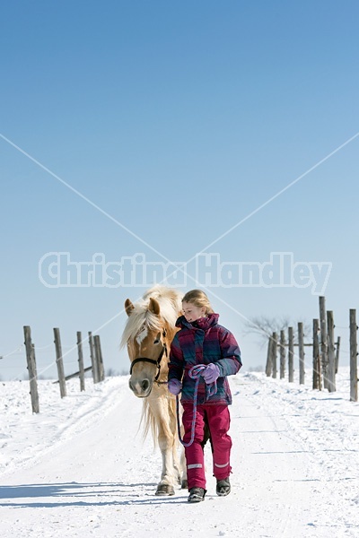 Young girl leading horse