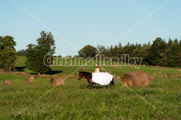 Woman riding horse wearing a wedding dress