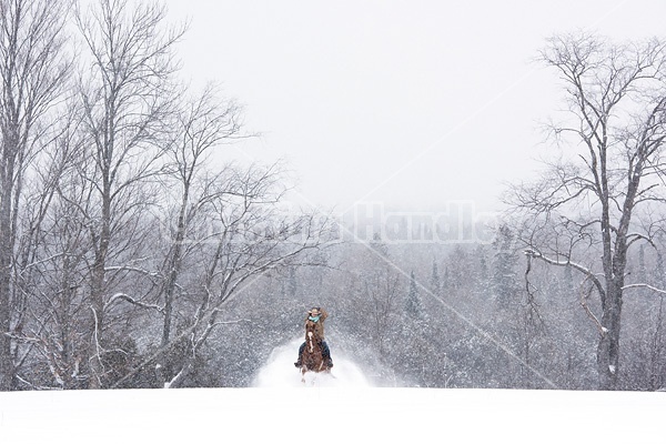 Young woman riding horse in snowstorm in Ontario Canada