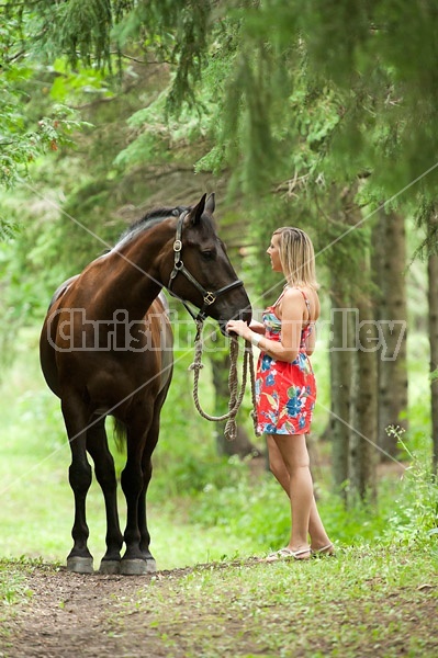 Young woman with her dark bay horse