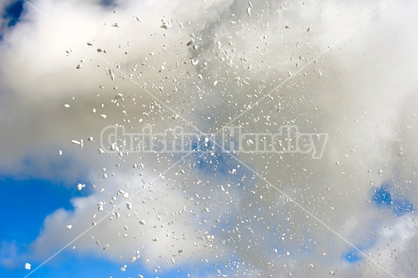 Photo of snow from snowblower against blue sky