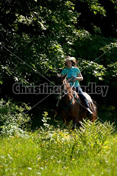 Woman trail riding on Standardbred mare