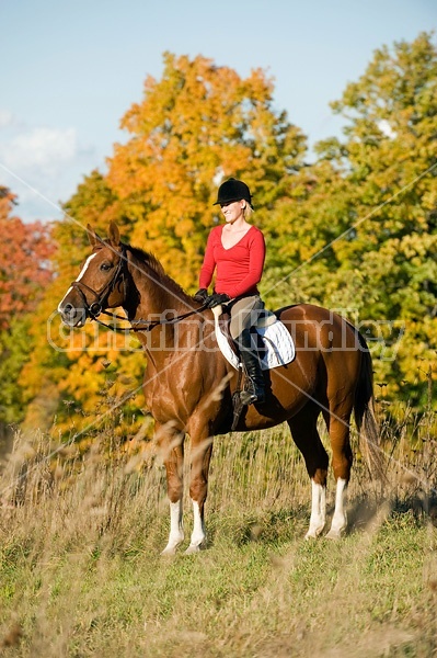 Young woman horseback riding in the fall of the year.